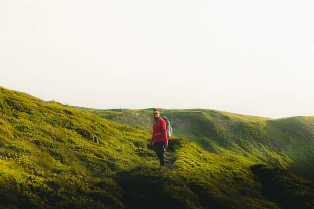 istock Man backpacker having the best time outdoors hiking in the mountains during sunset 1266947741