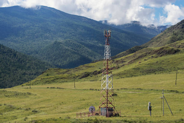 Red and white cell tower in a wild mountainous area.
