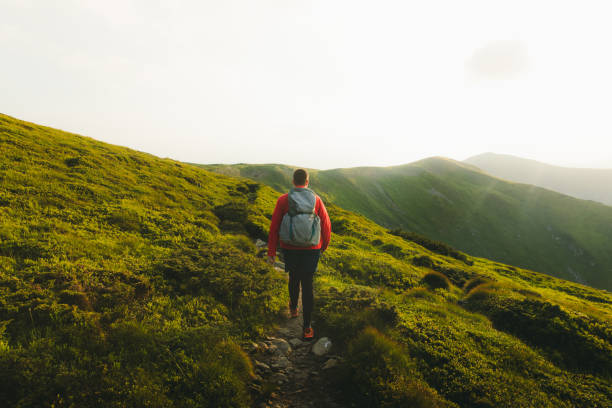 istock Man backpacker having the best time outdoors hiking in the mountains during sunset 1266948312