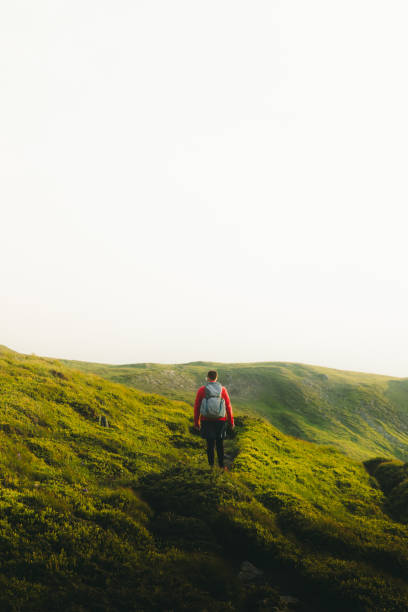 istock Man backpacker having the best time outdoors hiking in the mountains during sunset 1266948322