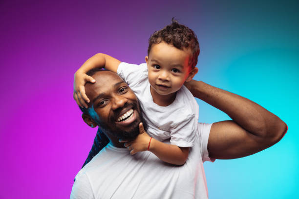 네온의 그라데이션 스튜디오 배경에 아프리카계 미국인 아버지와 아들 초상화 - 아버지 뉴스 사진 이미지