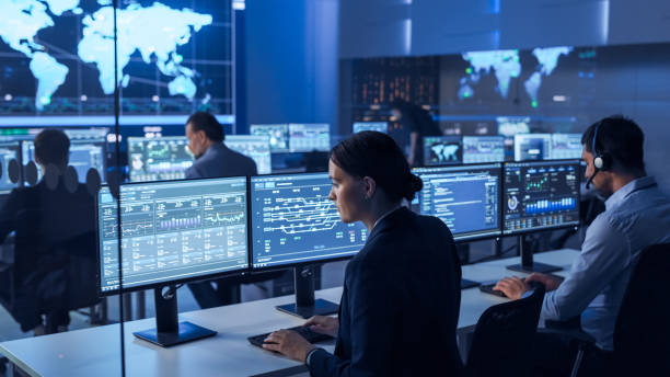 istock Team of Professional Computer Data Science Engineers Work on Desktops with Screens Showing Charts, Graphs, Infographics, Technical Business Data and Statistics. Dark Control and Monitoring Room. 1266953119
