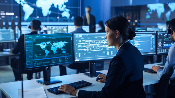 istock Team of Professional Computer Data Science Engineers Work on Desktops with Screens Showing World Map, Charts, Graphs Infographics Technical Business Data and Statistics. Dark Control Monitoring Room. 1266953138