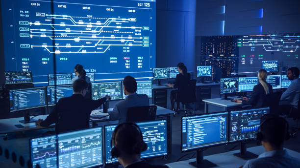 istock Team of Professional Computer Data Science Engineers Work on Desktops with Screens Showing Charts, Graphs, Infographics, Technical Neural Data and Statistics. Low Key Control and Monitoring Room. 1266953197