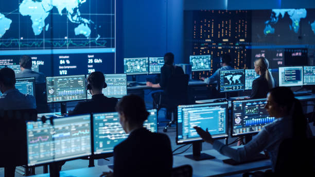 istock Team of Professional Computer Data Science Engineers Work on Desktops with Screens Showing Charts, Graphs, Infographics, Technical Neural Network Data and Statistics. Dark Control and Monitoring Room. 1266953251