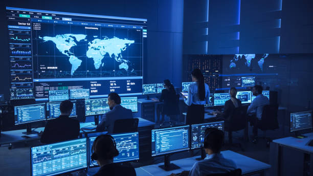 istock Team of Professional Computer Data Science Engineers Work on Desktops with Screens Showing Charts, Graphs, Infographics, Technical Neural Data and Statistics. Low Key Control and Monitoring Room. 1266953261