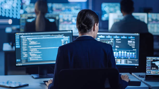 istock Confident Female Data Scientist Works on Personal Computer in Big Infrastructure Control and Monitoring Room with Neural Network. Woman Engineer in an Office Room with Colleagues. 1266953273