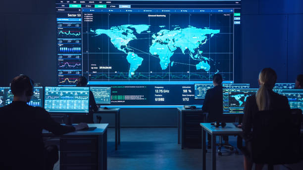 istock Team of Professional Computer Data Science Engineers Work on Desktops with Screens Showing Charts, Graphs, Infographics, Technical Neural Network Data and Statistics. Dark Control and Monitoring Room. 1266953312