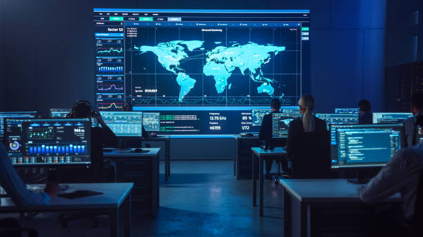 istock Team of Professional Computer Data Science Engineers Work on Desktops with Screens Showing Charts, Graphs, Infographics, Technical Neural Network Data and Statistics. Dark Control and Monitoring Room. 1266953320