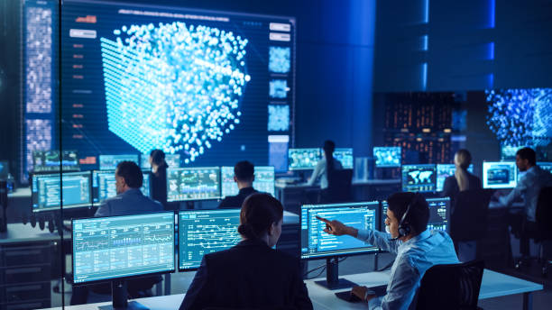 istock Team of Professional Computer Data Science Engineers Work on Desktops with Screens Showing Charts, Graphs, Infographics, Technical Neural Network Data and Statistics. Dark Control and Monitoring Room. 1266953322