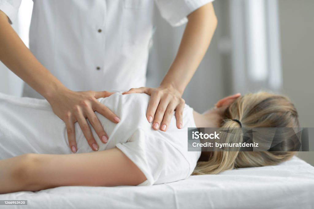 Woman having chiropractic back adjustment Osteopath Stock Photo