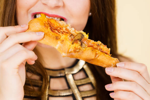 istock Woman eating hot pizza slice 1266957497