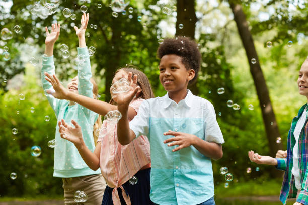 istock Children Playing with Bubbles in Park 1266959730