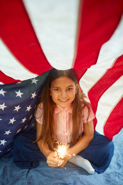 smiling little girl enjoying 4th of july celebration - child flag fourth of july little girls imagens e fotografias de stock