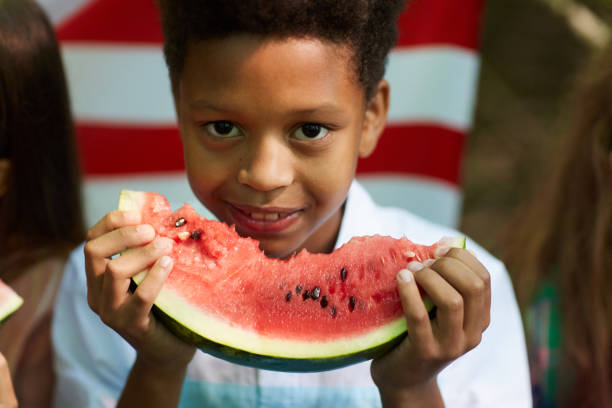 istock Smiling African-American Boy Eating Watermelon 1266959760