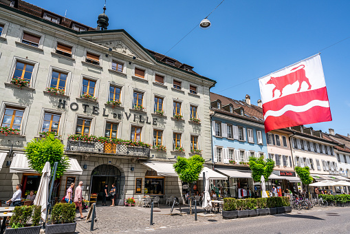 Bulle Switzerland , 27 June 2020 : Bulle city hall front view and city flag with a bull in Bulle La Gruyere Switzerland