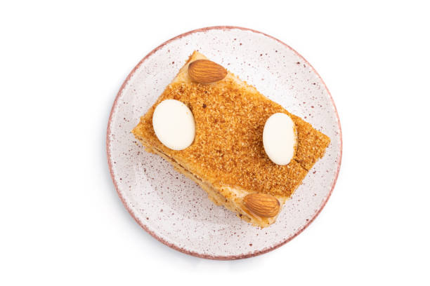 istock Honey cake with milk cream, caramel, almonds isolated on a white background. Top view, flat lay, close up. 1266961141