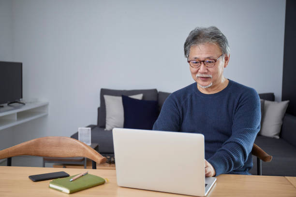 homem sênior operando um computador pessoal na sala - west old house decor - fotografias e filmes do acervo