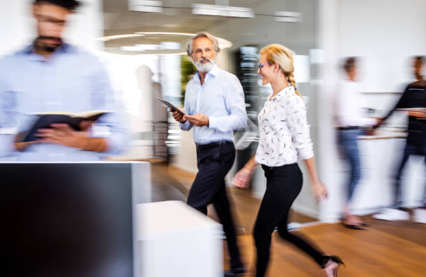 istock Business people discussing while walking in the corridor 1266963458