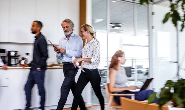istock Business people discussing while walking in the corridor 1266963850