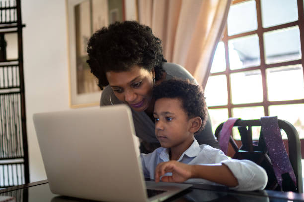 istock Mother helping son while he is studying on laptop at home 1266966291