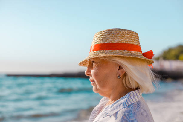 istock woman in straw hat looking at the sea 1266968953