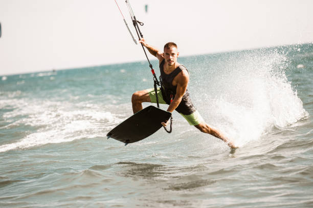 istock Kitesurfing Kiteboarding action photos man among waves quickly goes 1266971809