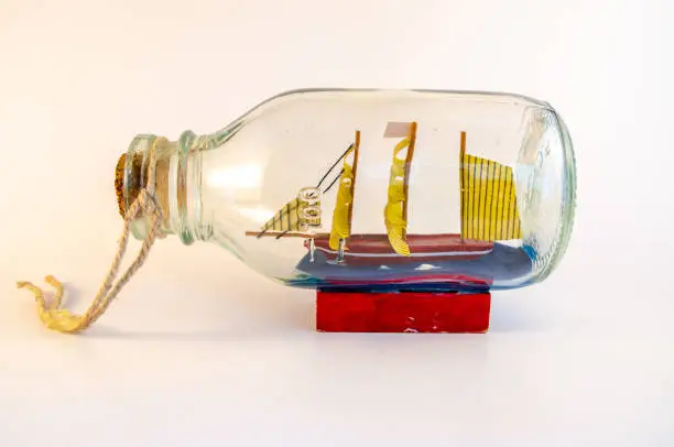 Sailingboat in a bottle isolated on white, side angle