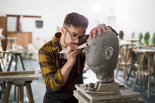 Male Sculptor working on a clay bust