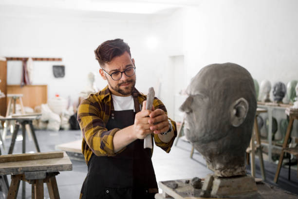 istock Male Sculptor working on a clay bust measuring parts 1266974124