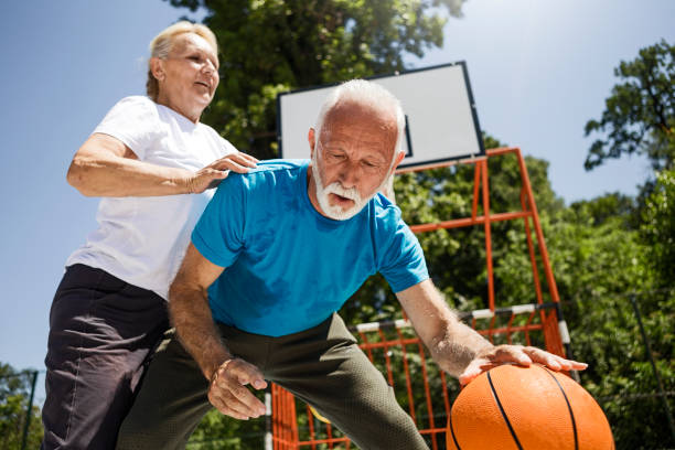 istock Senior couple having fun playing basketball 1266974604