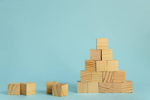 istock Construction of wooden cubes on blue background with copy space. Mockup composition for design 1266978040