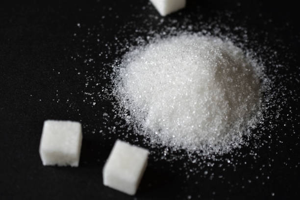 istock Scattered sugar in a pile and refined sugar cubes on a black background 1266978709
