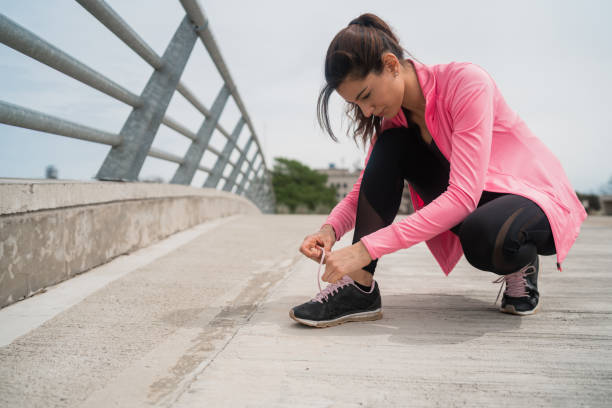 istock Athletic woman  tying her shoelaces. 1266980847