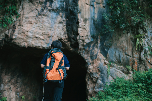 an asian chinese mid adult female travel hiking exploring Ipoh Perak Malaysia caves forest with backpack