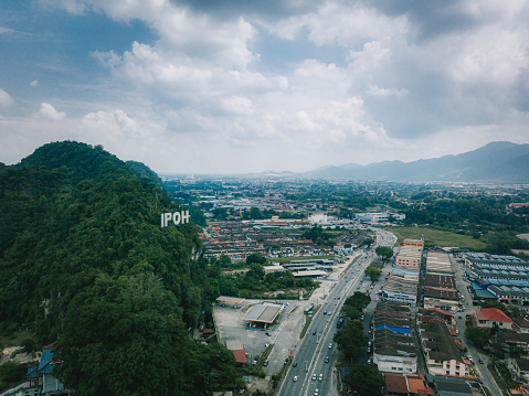 drone point of view Ipoh city with signage on mountain during day time