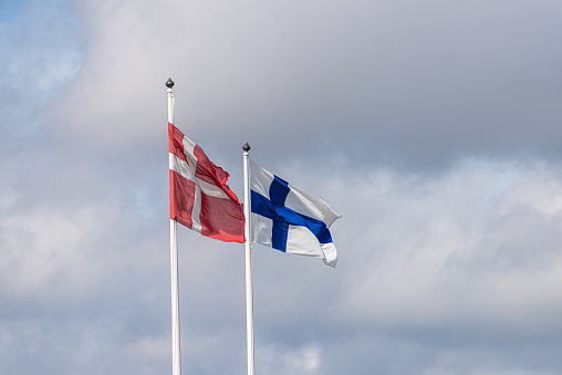 Flags of Demnark and Finland waving in the breeze.