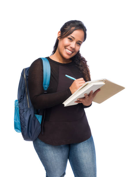 istock Lovely female student writing and smiling at camera 1266982614