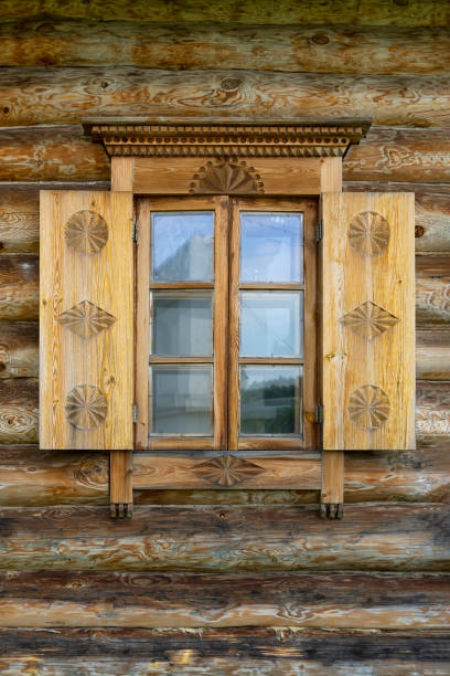 istock Natural wooden window with shutters, decorated with carved patterns, old village house 1266986187