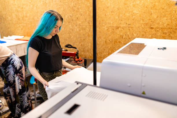 istock In digital printing workshop female worker preparing T-shirt for printing 1266994533