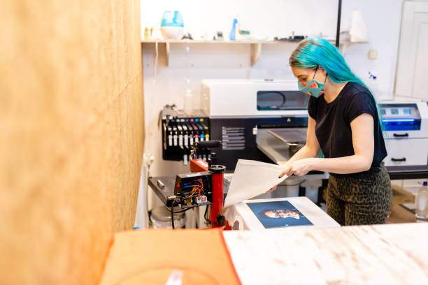 istock Responsible business owner using silk screen print machine to make amazing art of textile 1266995055
