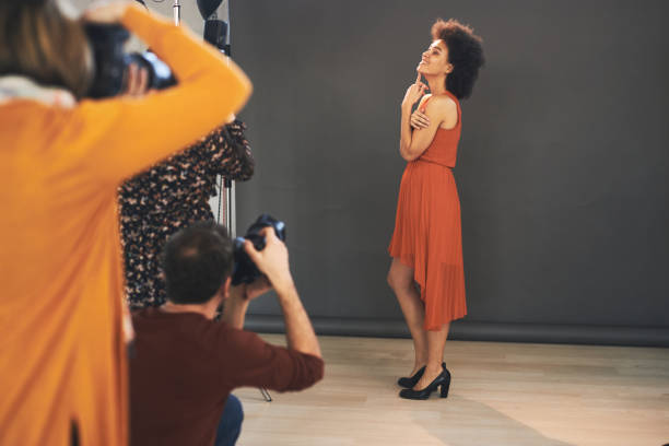 istock Attendees taking photography lessons form experienced photographer in studio. 1266995158