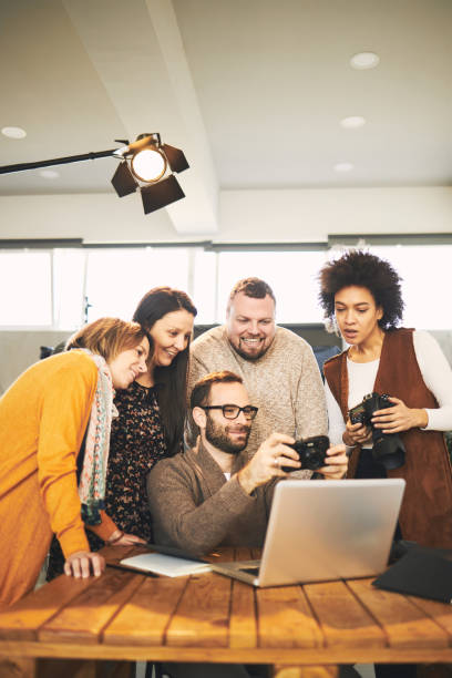 istock Attendees taking photography lessons form experienced photographer in studio. 1266995192