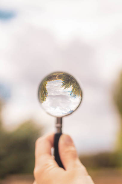 istock magnifying glass pointing at cloudy blue sky 1266995792