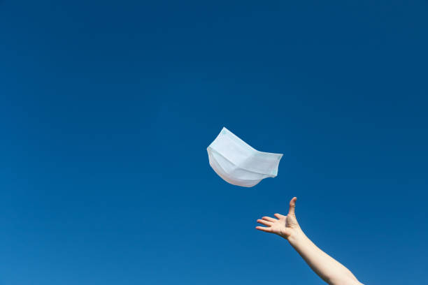 istock Female hand is throwing a protective face mask 1266996069