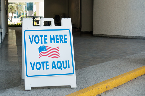 Vote here sign in English and Spanish at a polling place.