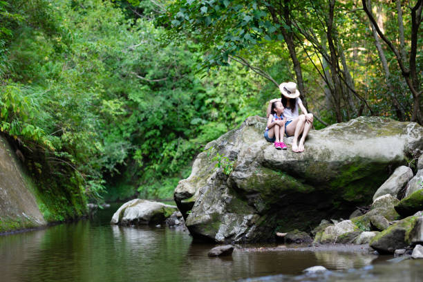 istock Mother and daughter playing in mountain stream 1266999584