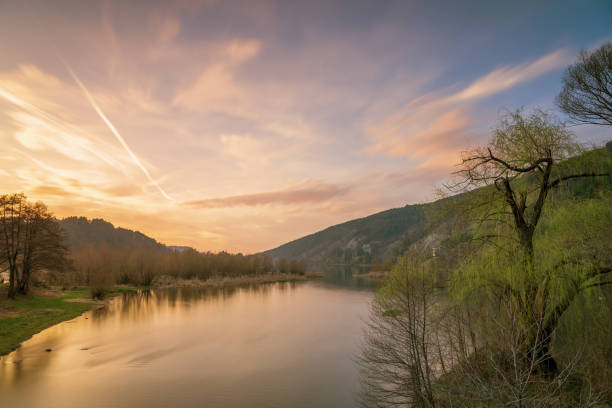 istock Sunset on the lake with forest with green grass 1267000033