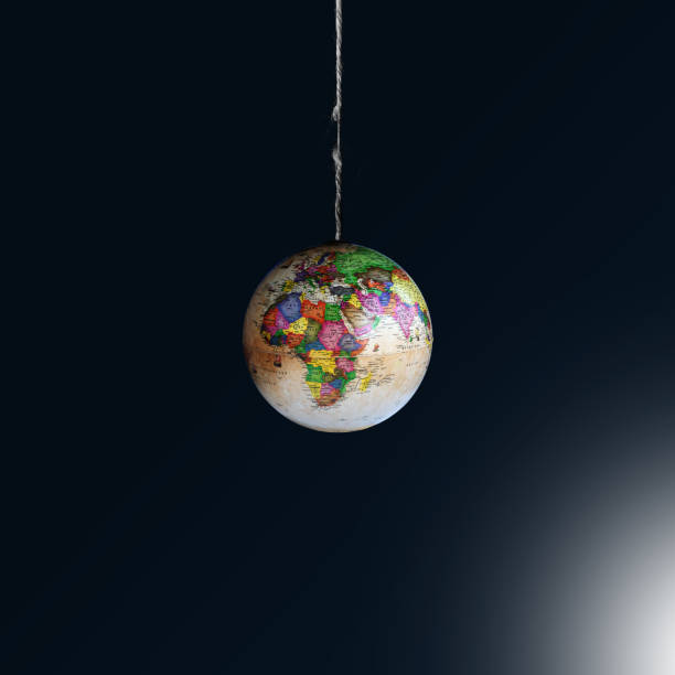 istock Globe is hanging by a thread on dark background. Our planet rescue concept. Earth in the balance. World is in danger. Copy space. 1267002590