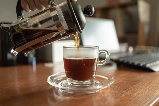 versare il caffè della stampa francese in una tazza sul tavolo da lavoro a casa - espresso coffee cafe making foto e immagini stock